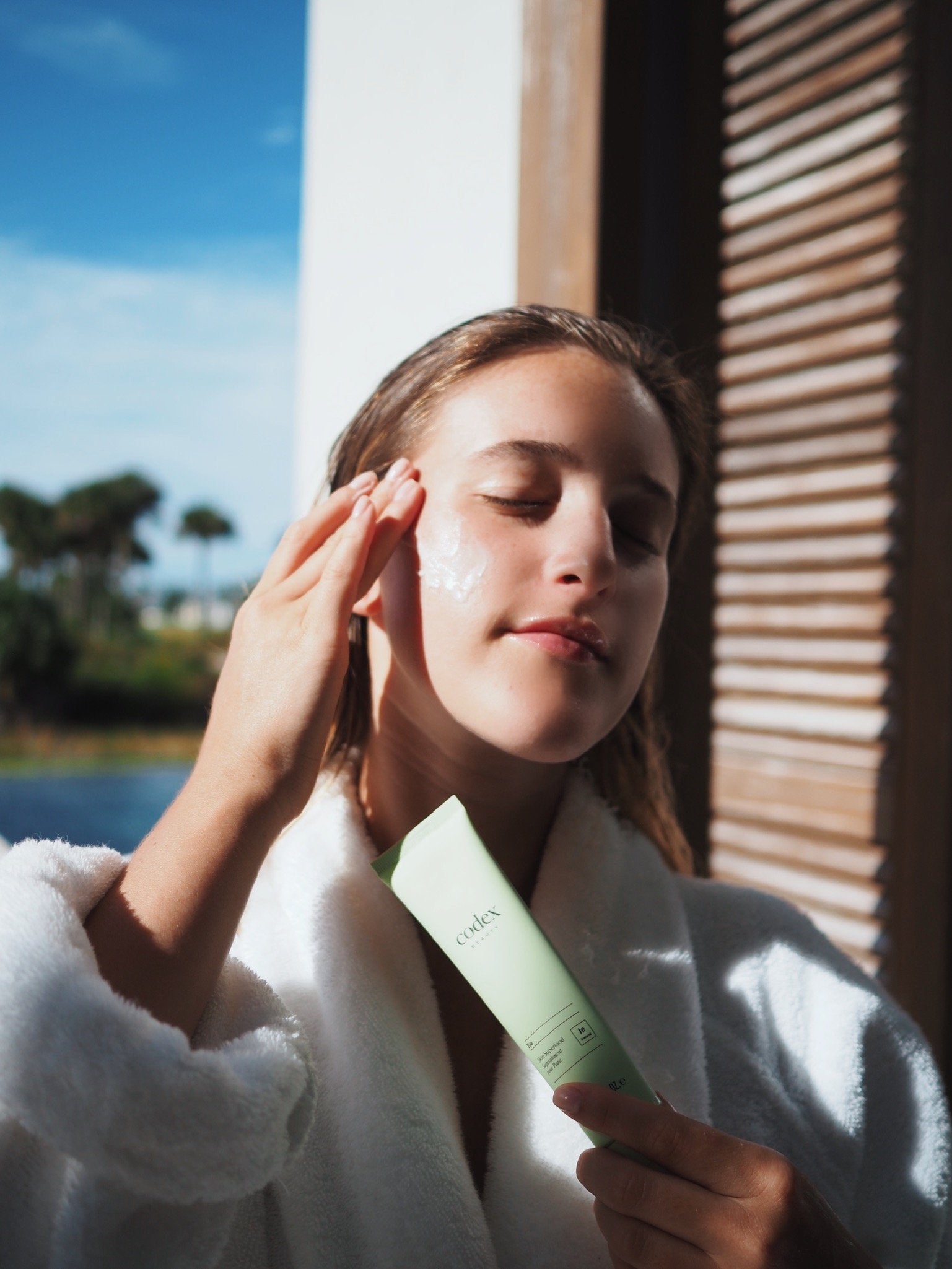 Jamie putting codex skincare product on face