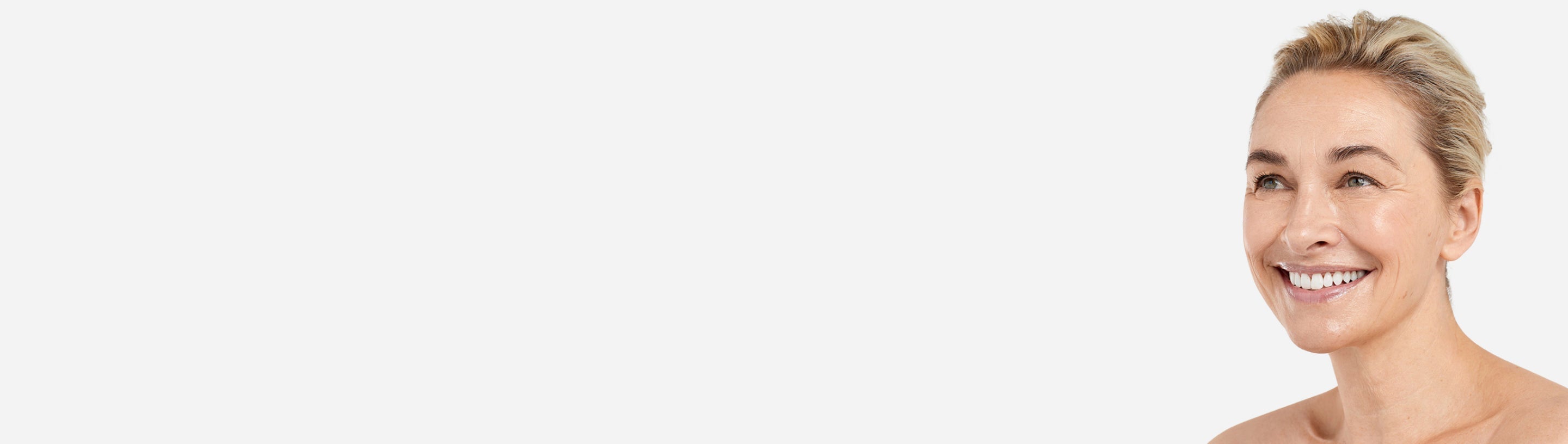 Side profile of a smiling woman in front of a white background.